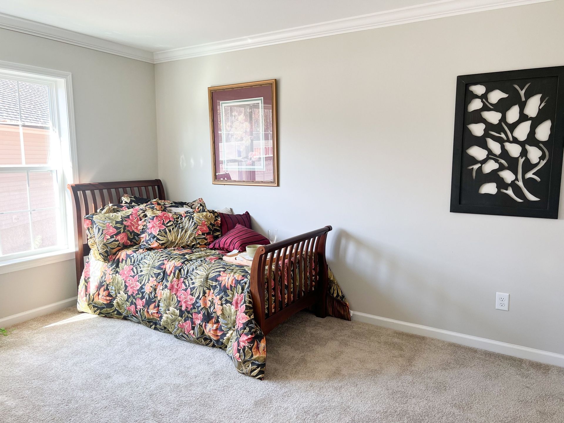 A bedroom with a day bed and a picture on the wall.