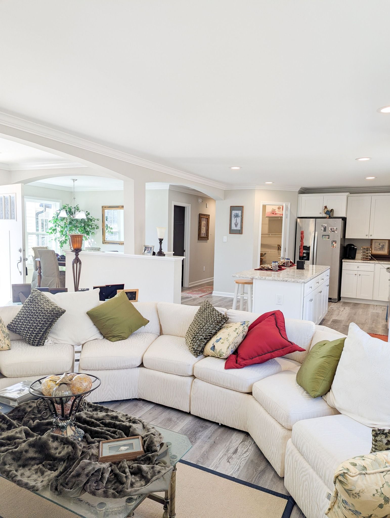 A living room with a couch , chairs , and a coffee table.