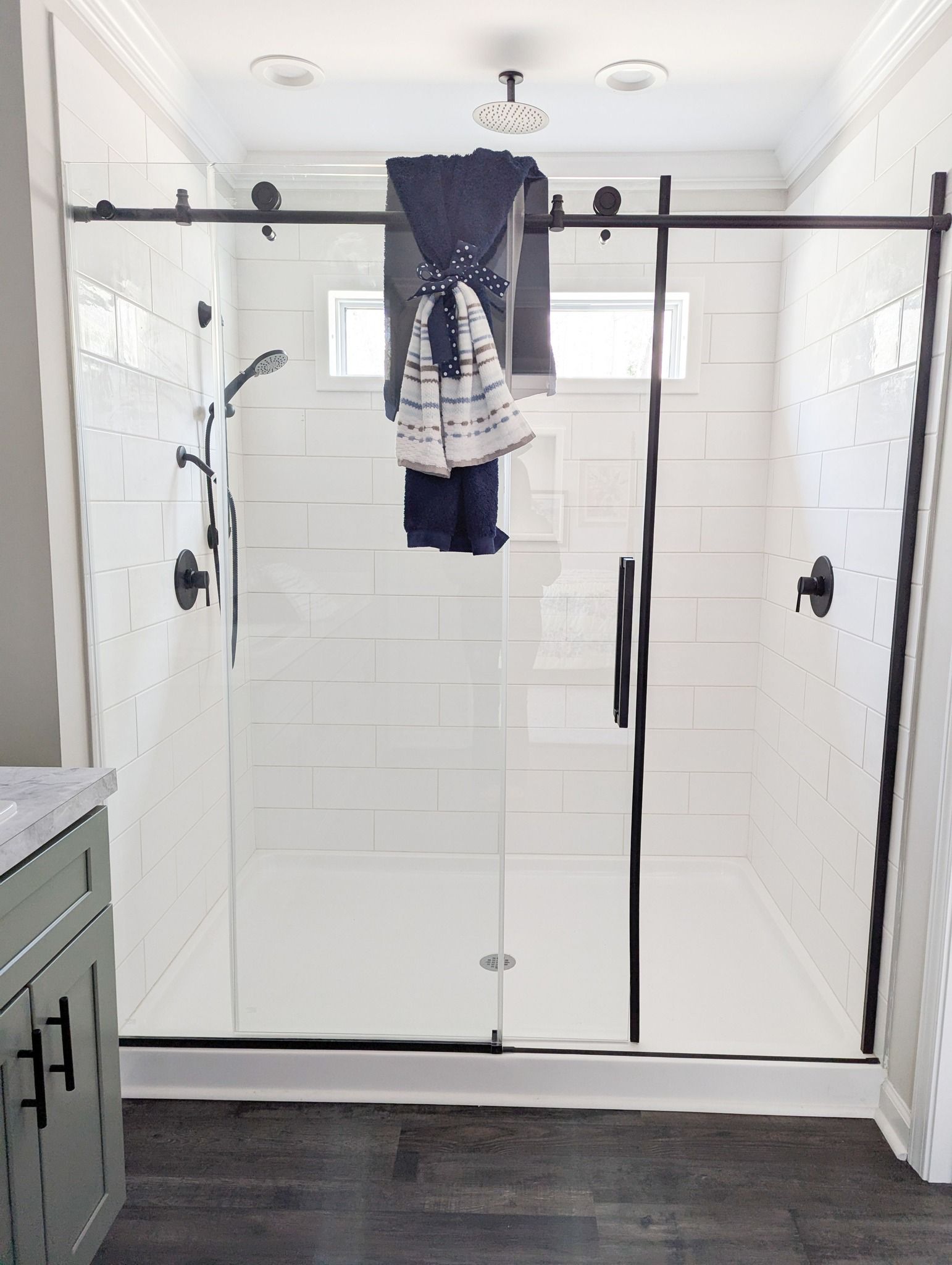 A bathroom with a sliding glass shower door and a sink.