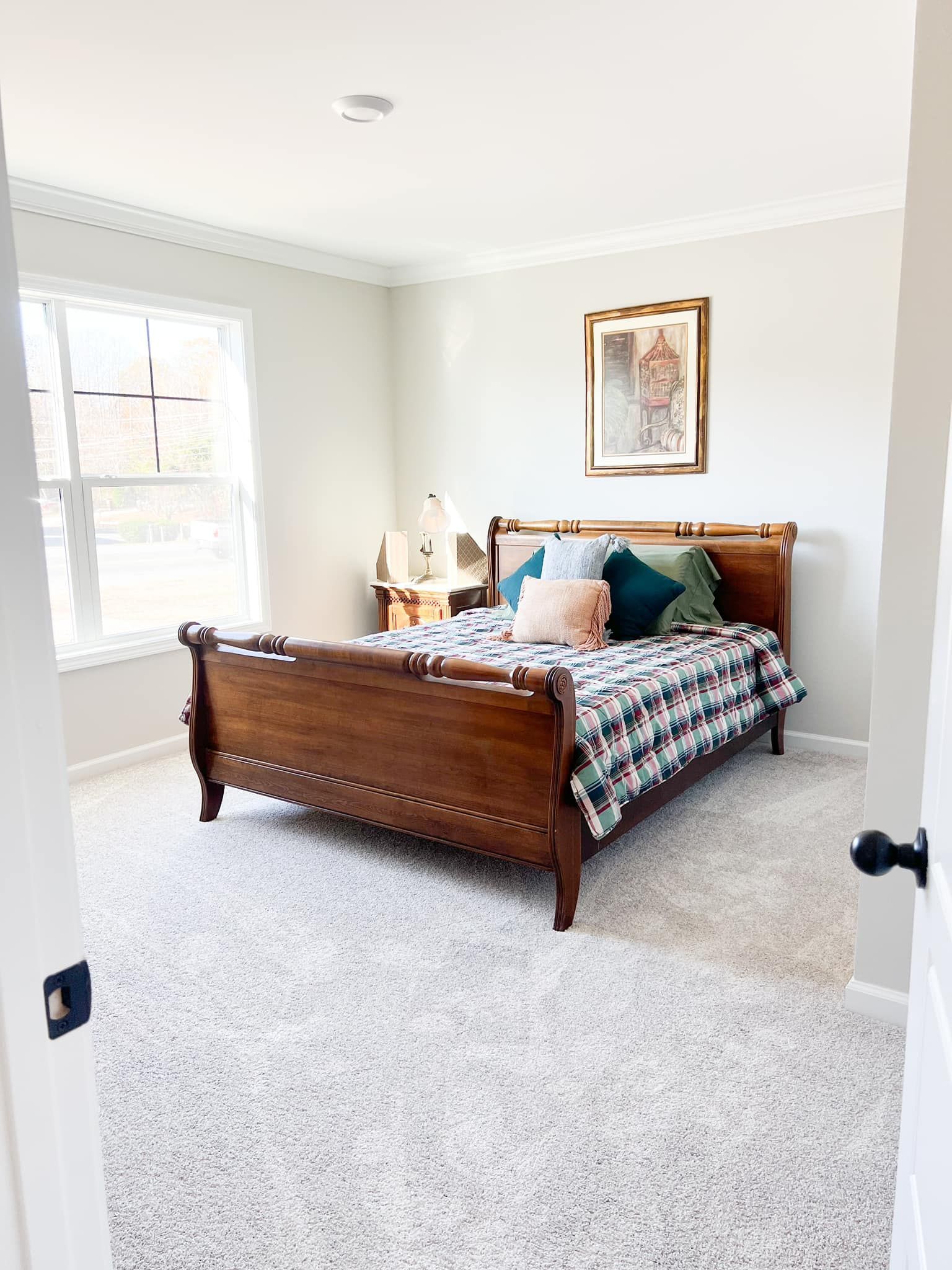 A bedroom with a large bed and a window.