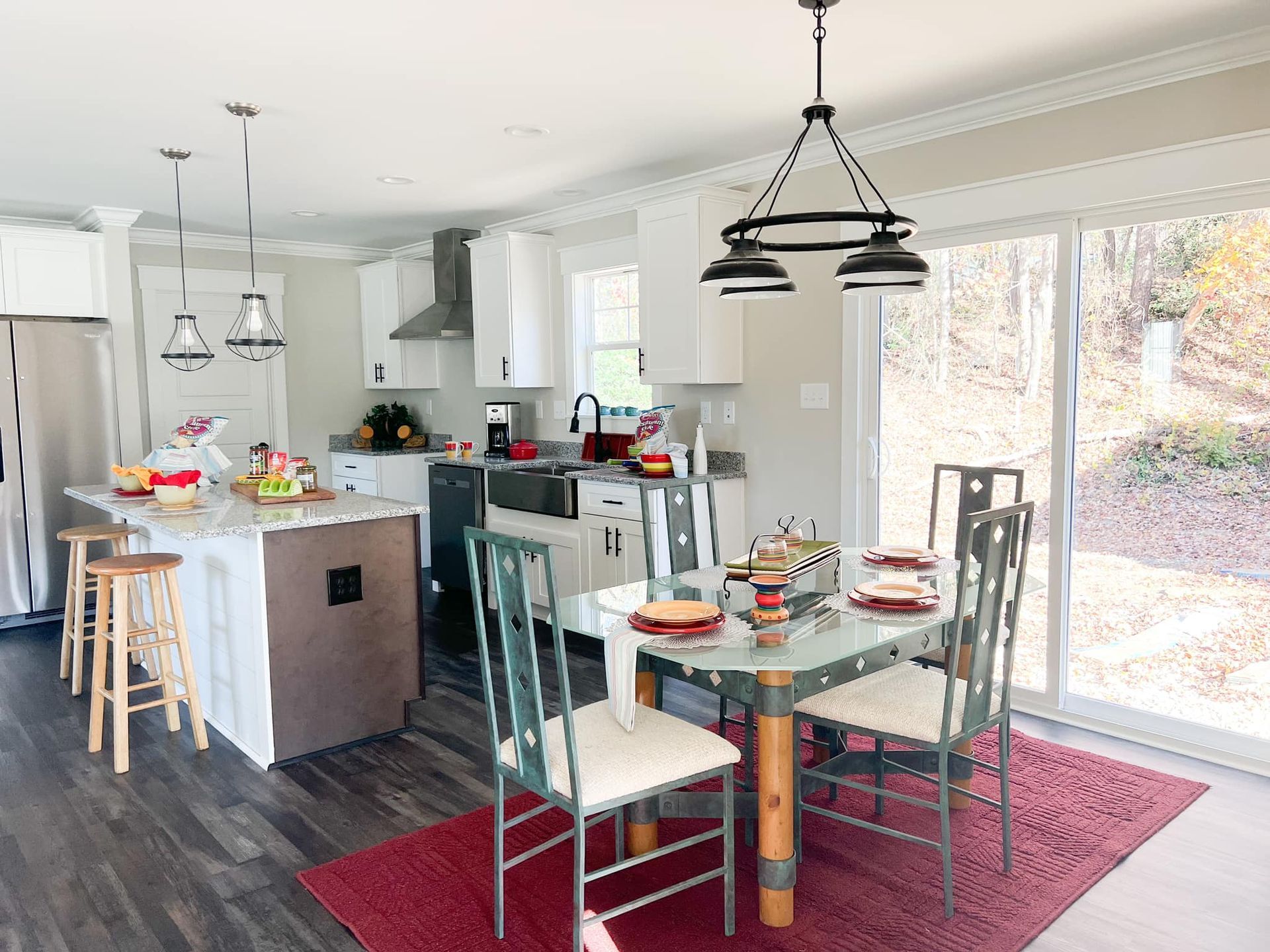 A kitchen with a dining table and chairs and a sliding glass door.