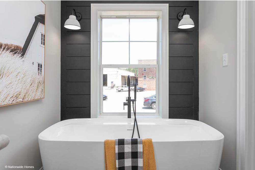 A bathroom with a large tub and a window.