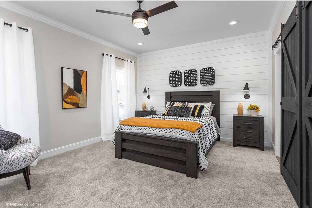 A bedroom with a bed, nightstands, and a ceiling fan.