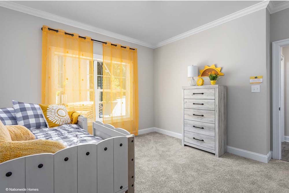 A bedroom with a bed with yellow curtains.