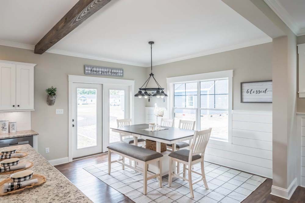 A dining room with a table and chairs and a bench.