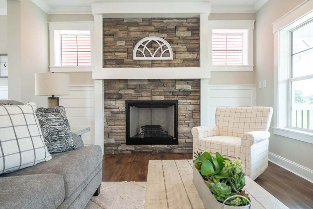 A living room with a fireplace, couch, chair and coffee table.
