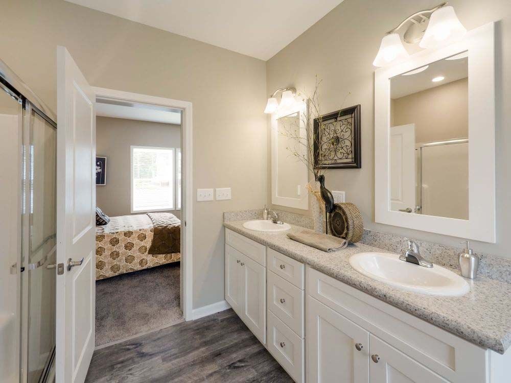A kitchen with white cabinets, granite counter tops, stainless steel appliances and a large island.