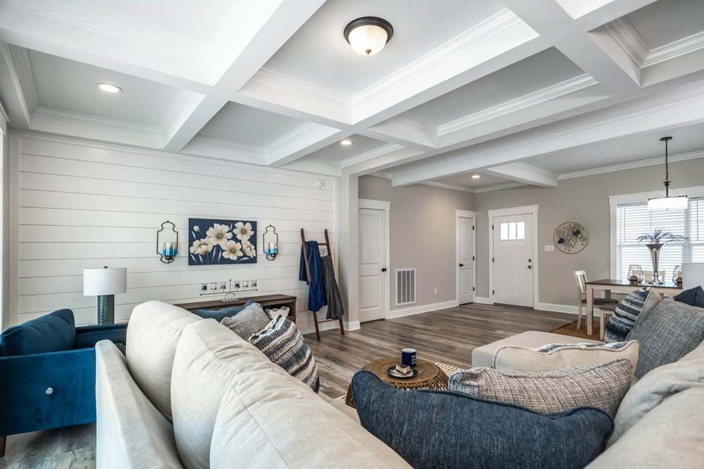 A living room filled with furniture and a coffered ceiling.