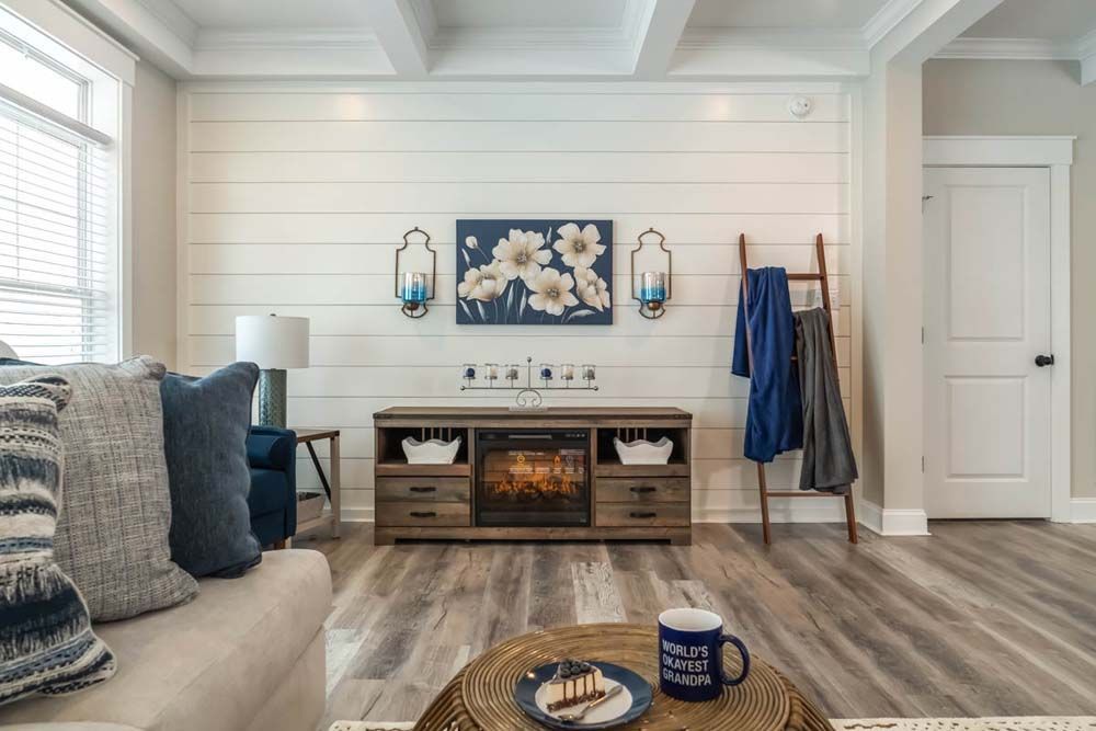 A living room with a couch, coffee table, fireplace and ladder.
