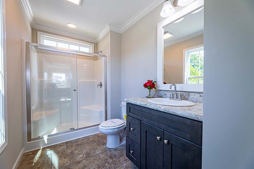 A bathroom with a toilet, sink, and shower.