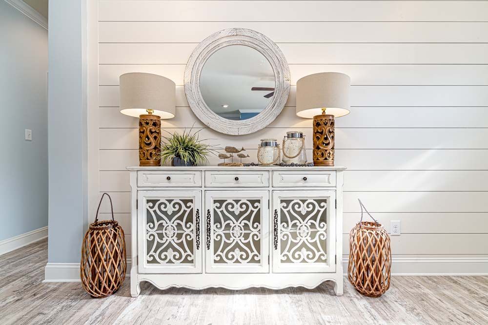 A white dresser with a mirror on top of it in a living room.