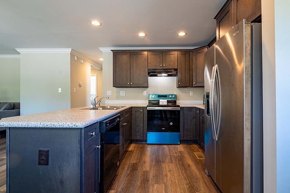 A kitchen with stainless steel appliances and wooden floors.