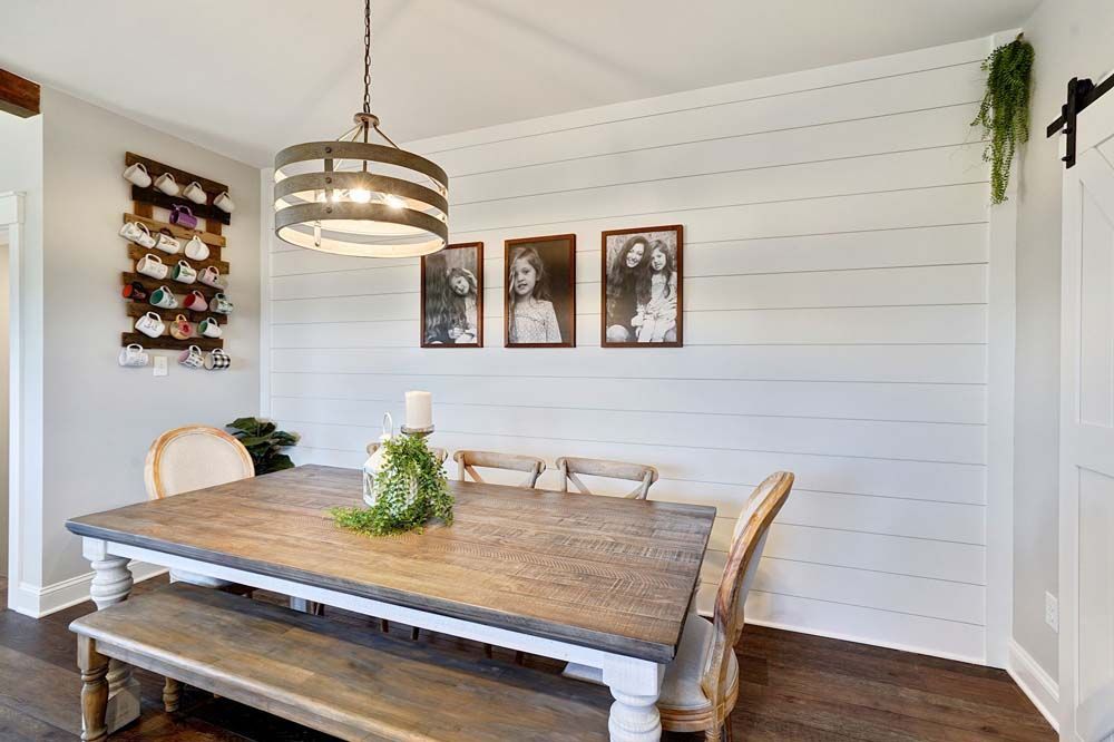 A dining room with a wooden table and chairs and a bench.