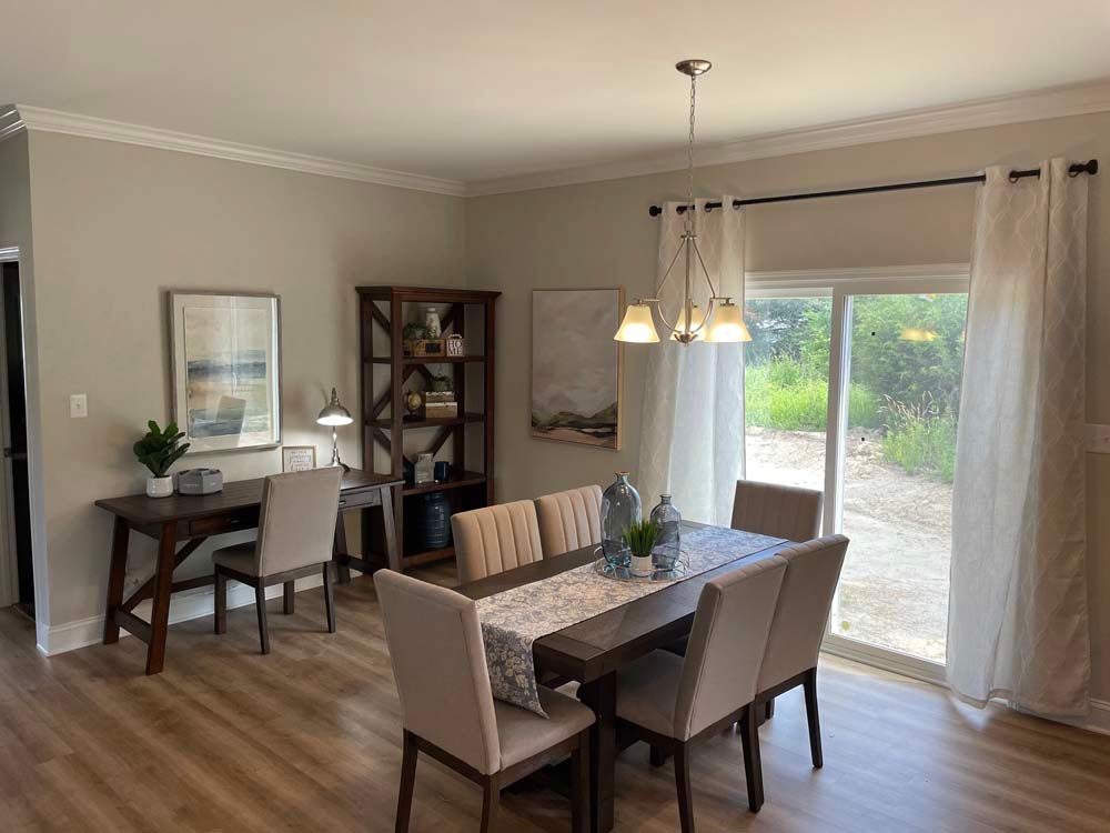 A dining room with a table and chairs and a sliding glass door.