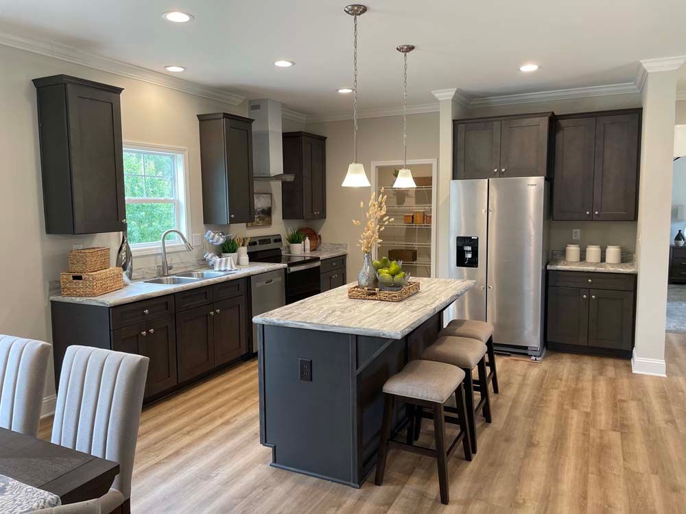 A kitchen with stainless steel appliances and a large island in the middle.