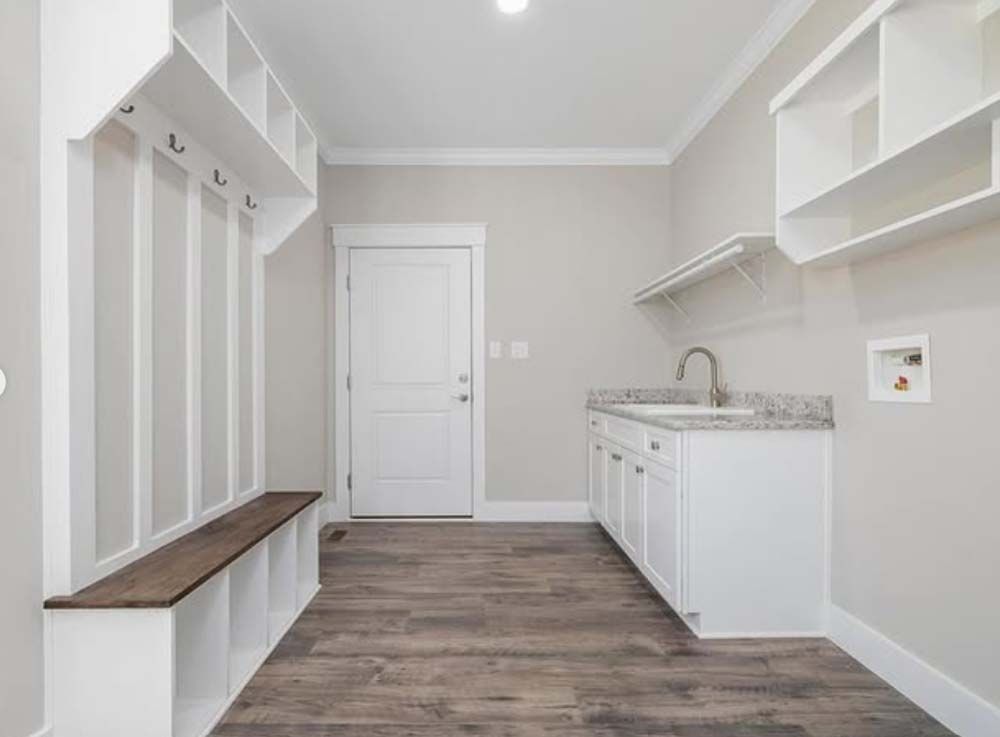It is a laundry room with a sink and a bench.