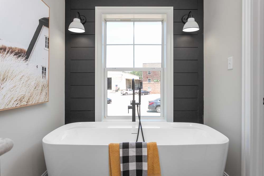 A bathroom with a bathtub and a window.