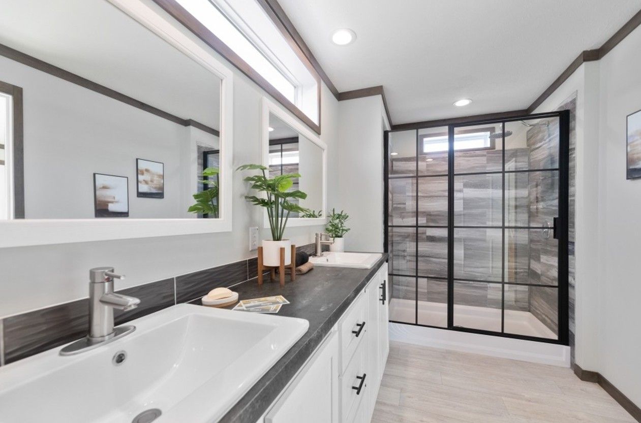 A bathroom with a sink and a walk in shower.