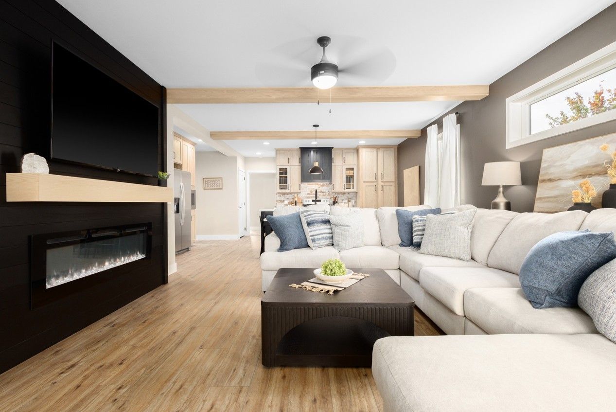 A living room with a couch, coffee table and fireplace.