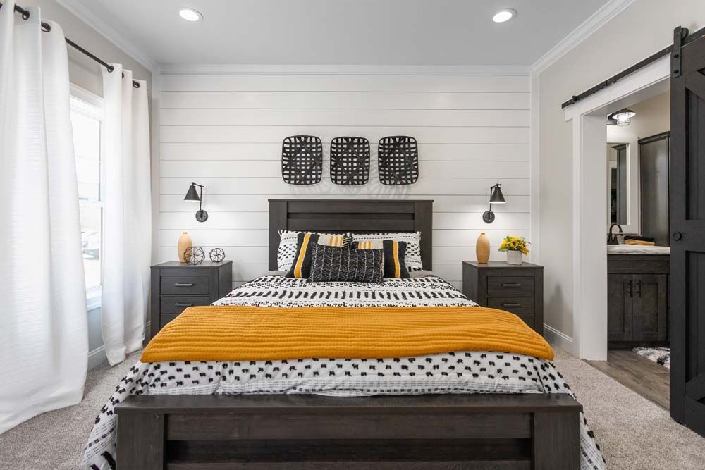 A bedroom with a bed, nightstands, and a sliding barn door.