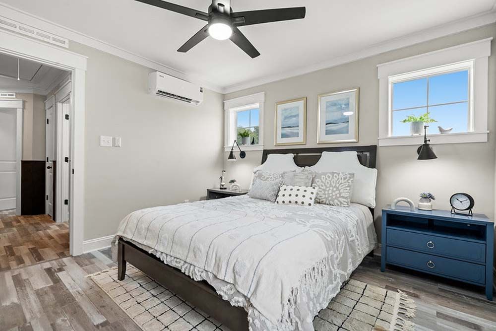A bedroom with a bed, nightstand, and ceiling fan.