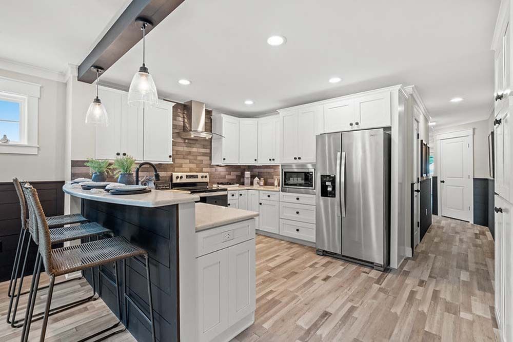 A kitchen with stainless steel appliances, cabinets, and hardwood floors.