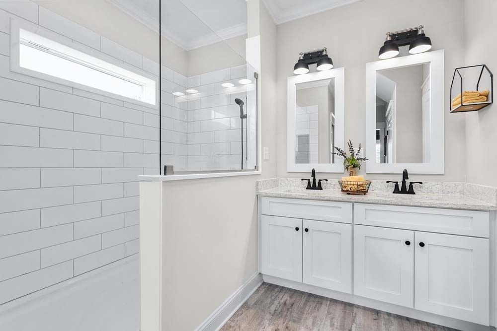 A bathroom with sinks, mirrors and a walk in shower.