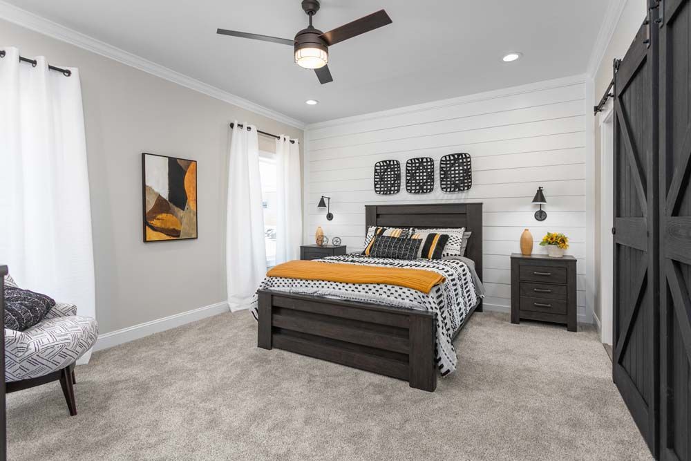 A living room with a couch, chairs, and a kitchen.