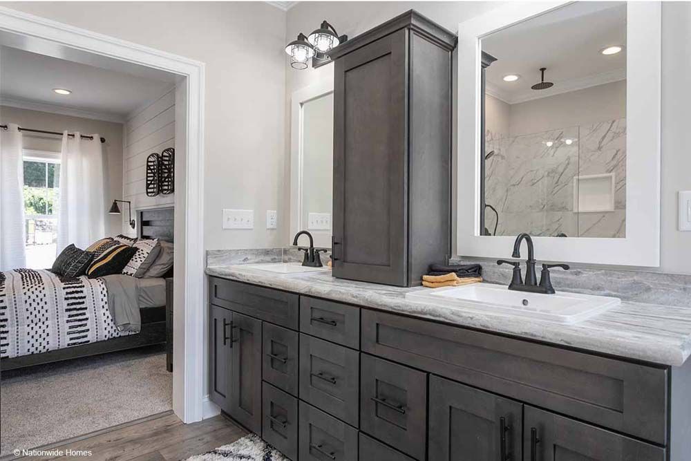 A bathroom with two sinks, a mirror and a walk in shower.