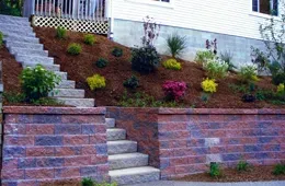 A brick wall with stairs leading up to a house.