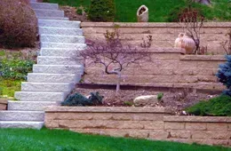 A set of stairs leading up to a brick wall in a garden.