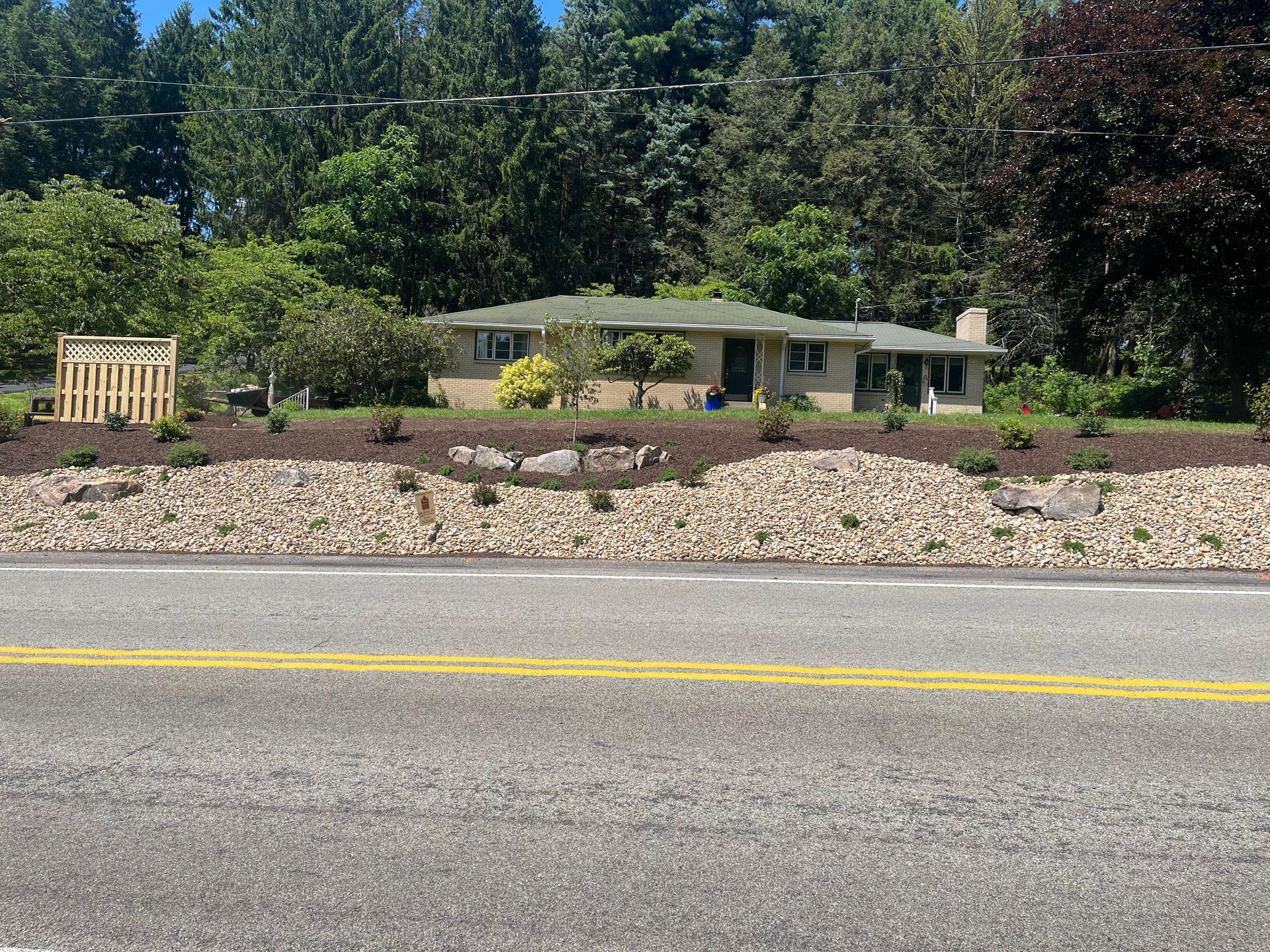 A house is sitting on a hill next to a road.