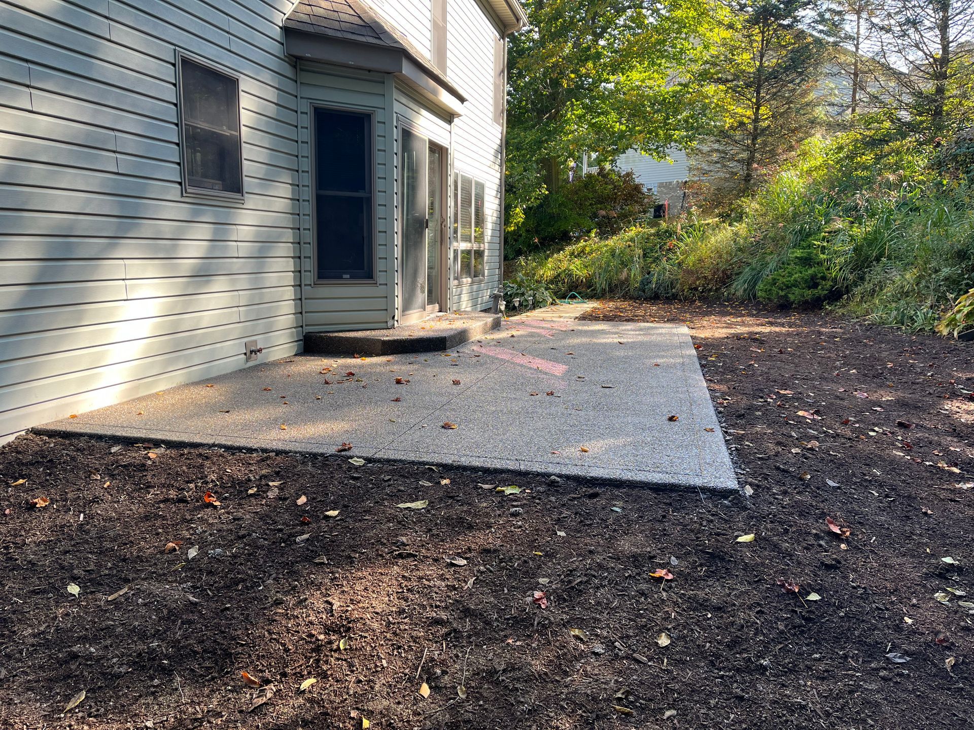 There is a patio in the backyard of a house.
