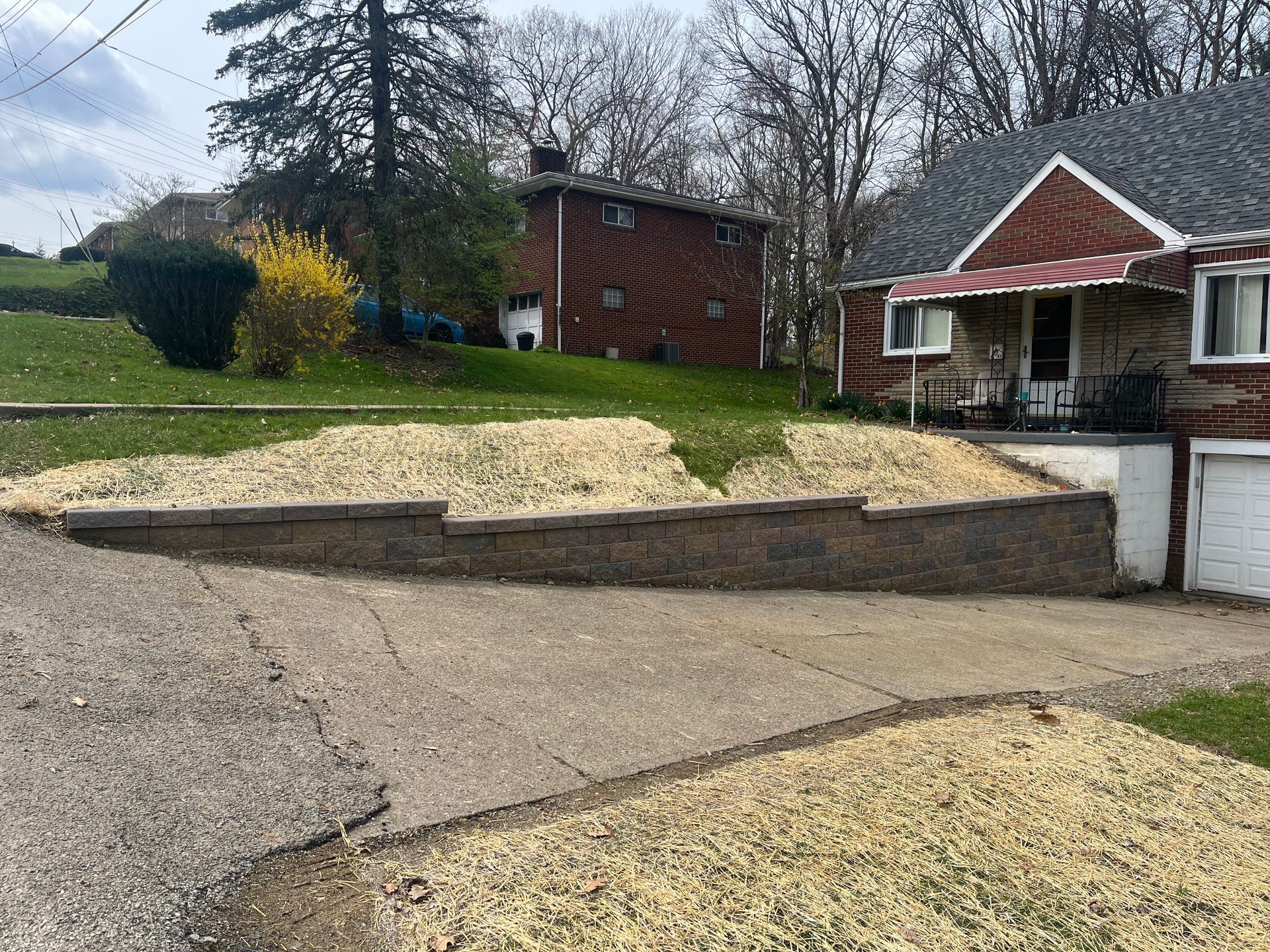 A house with a brick wall in front of it and a driveway.