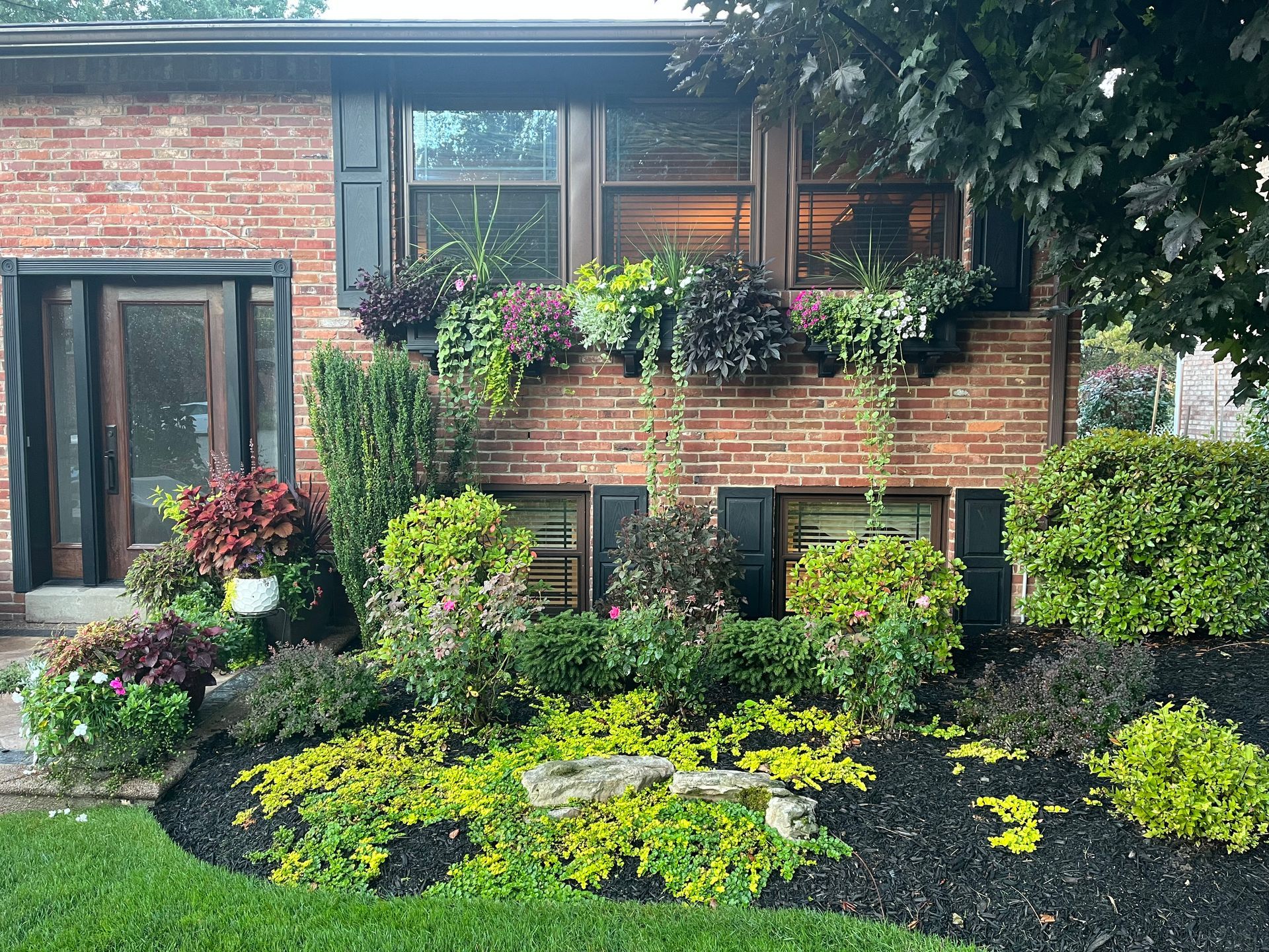 A brick house with a garden in front of it
