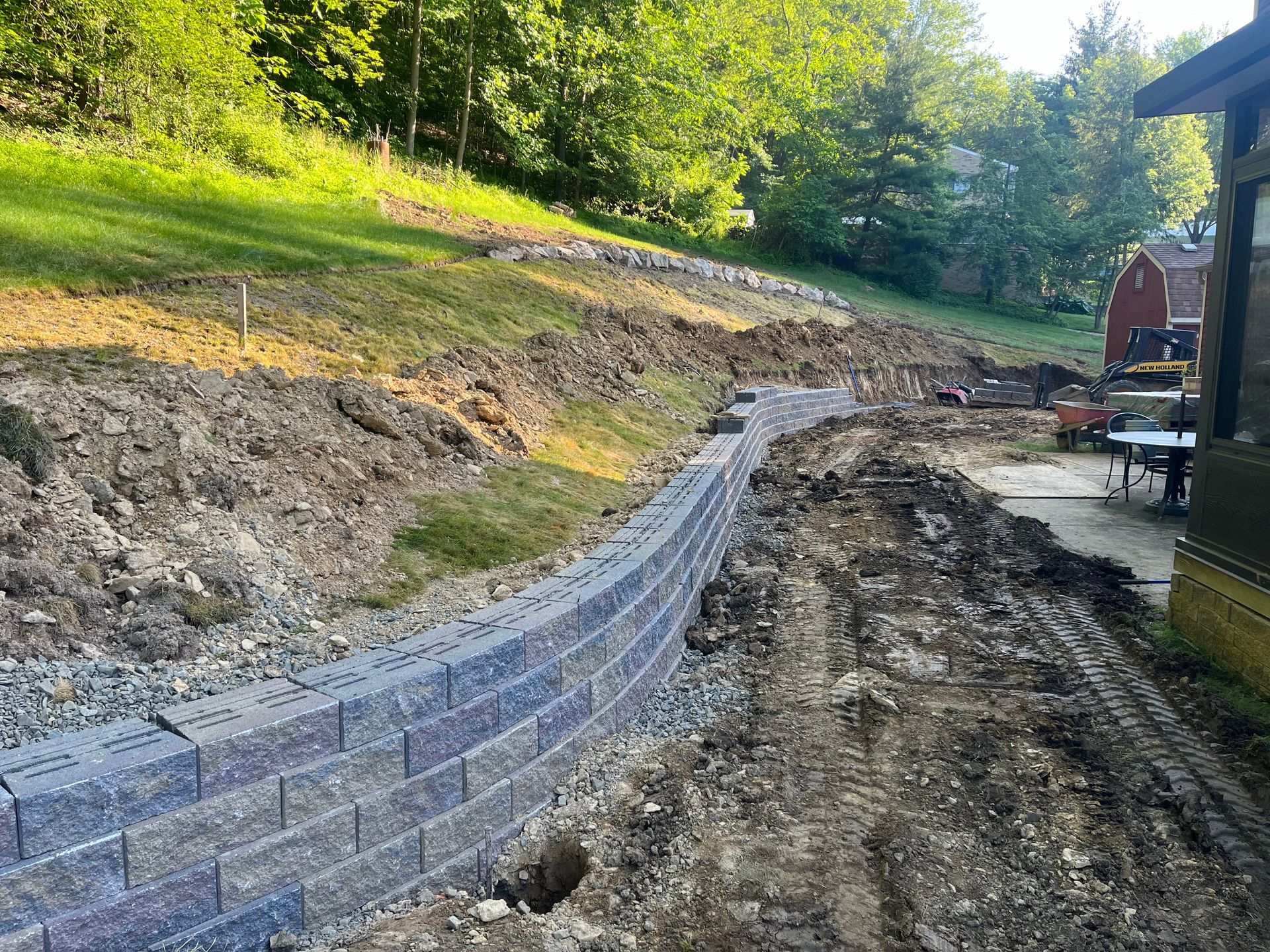 A brick wall is being built on top of a dirt hill.