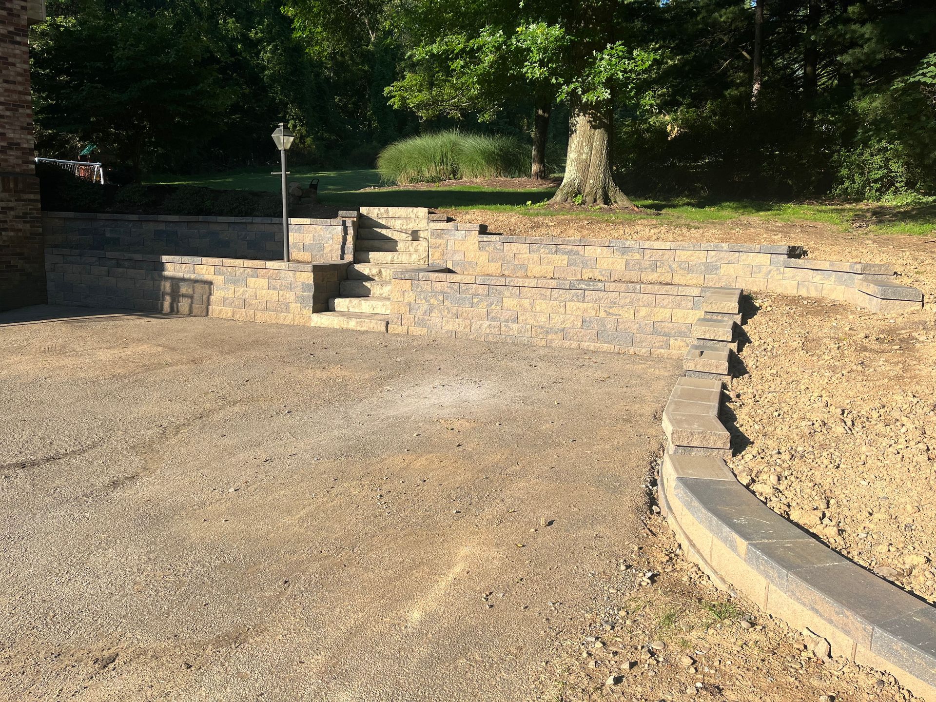 A brick walkway is being built in the middle of a dirt road.