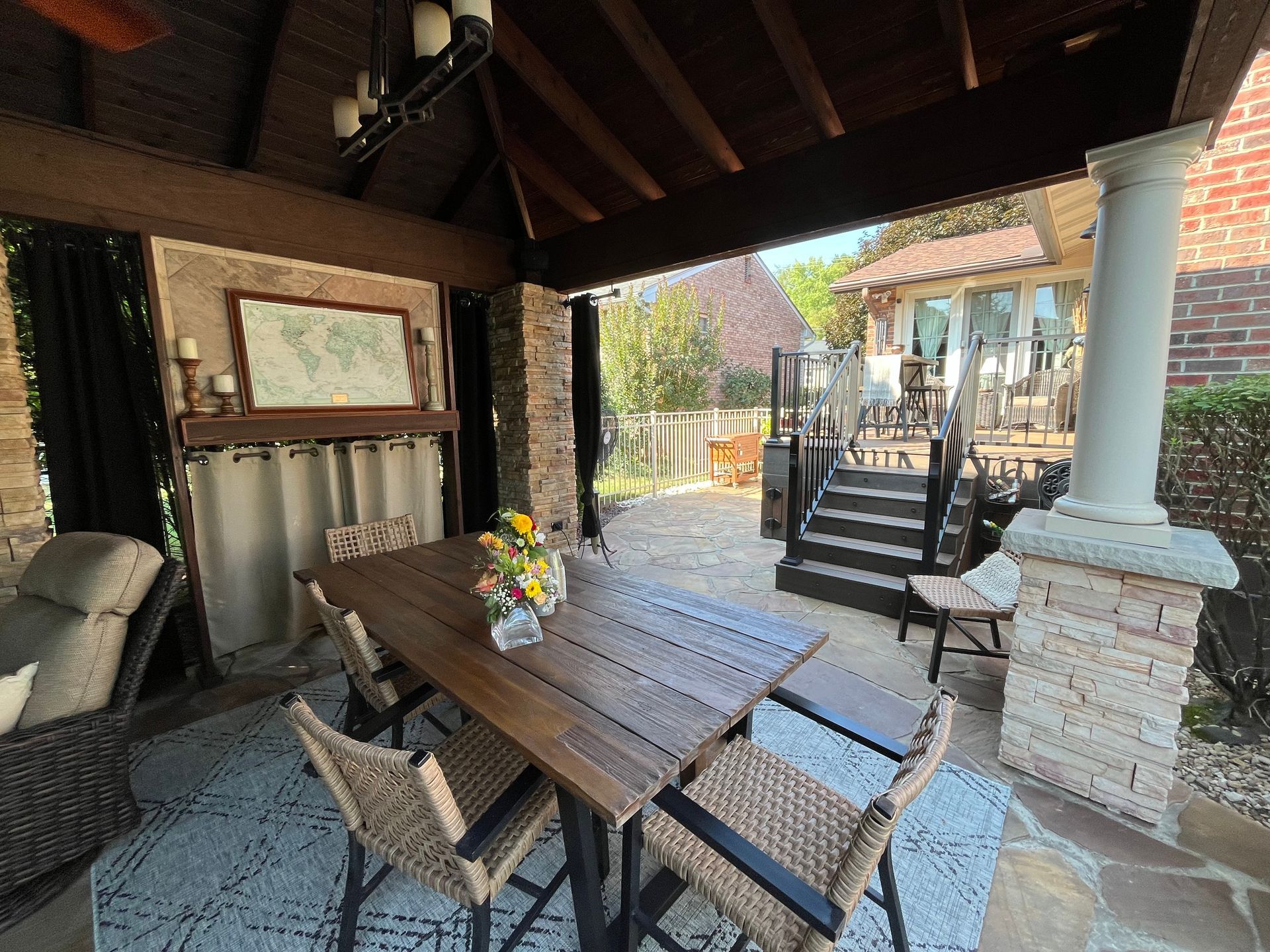 A patio with a table and chairs under a gazebo.
