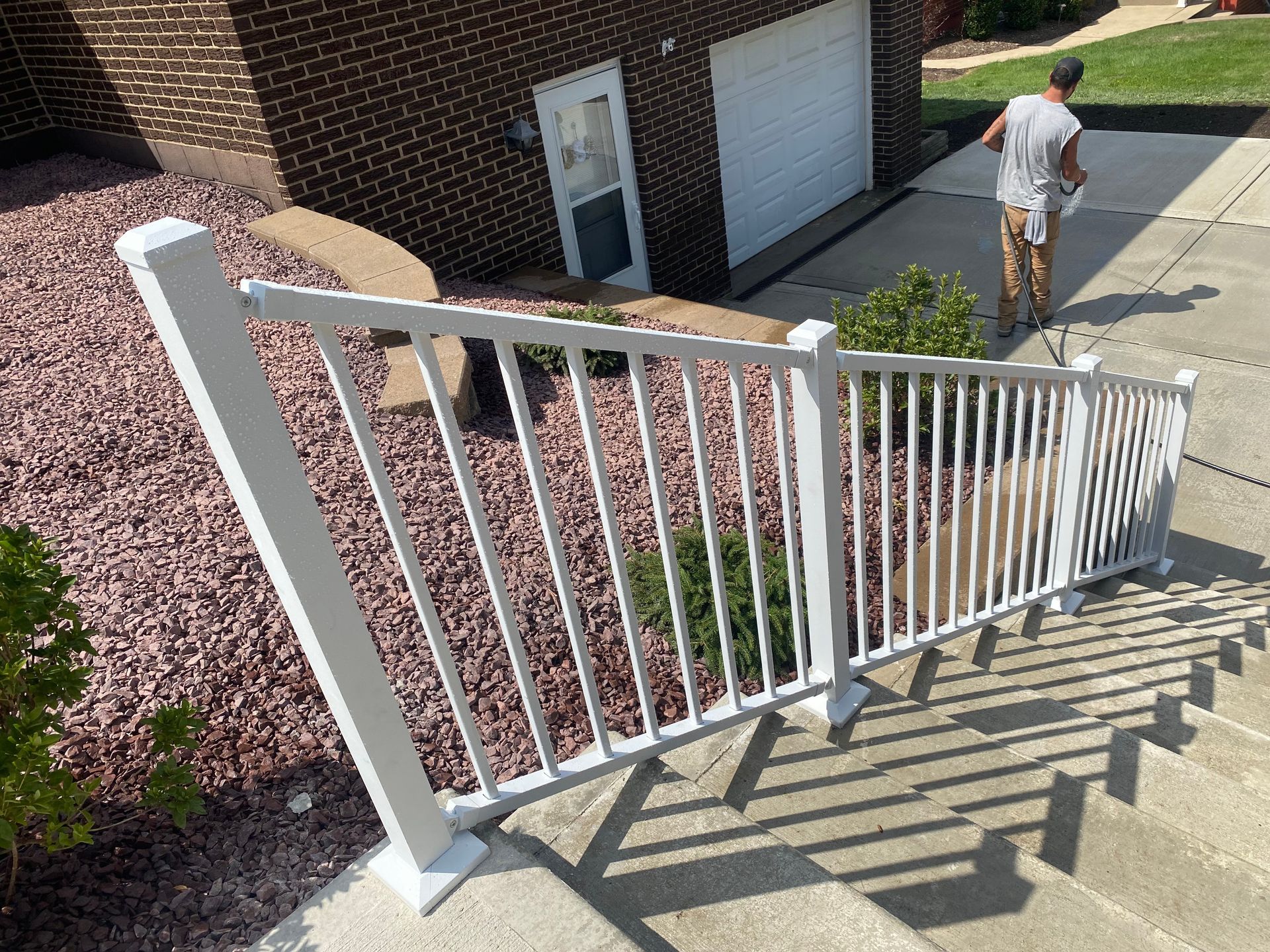 A man is walking down a set of stairs next to a white railing.
