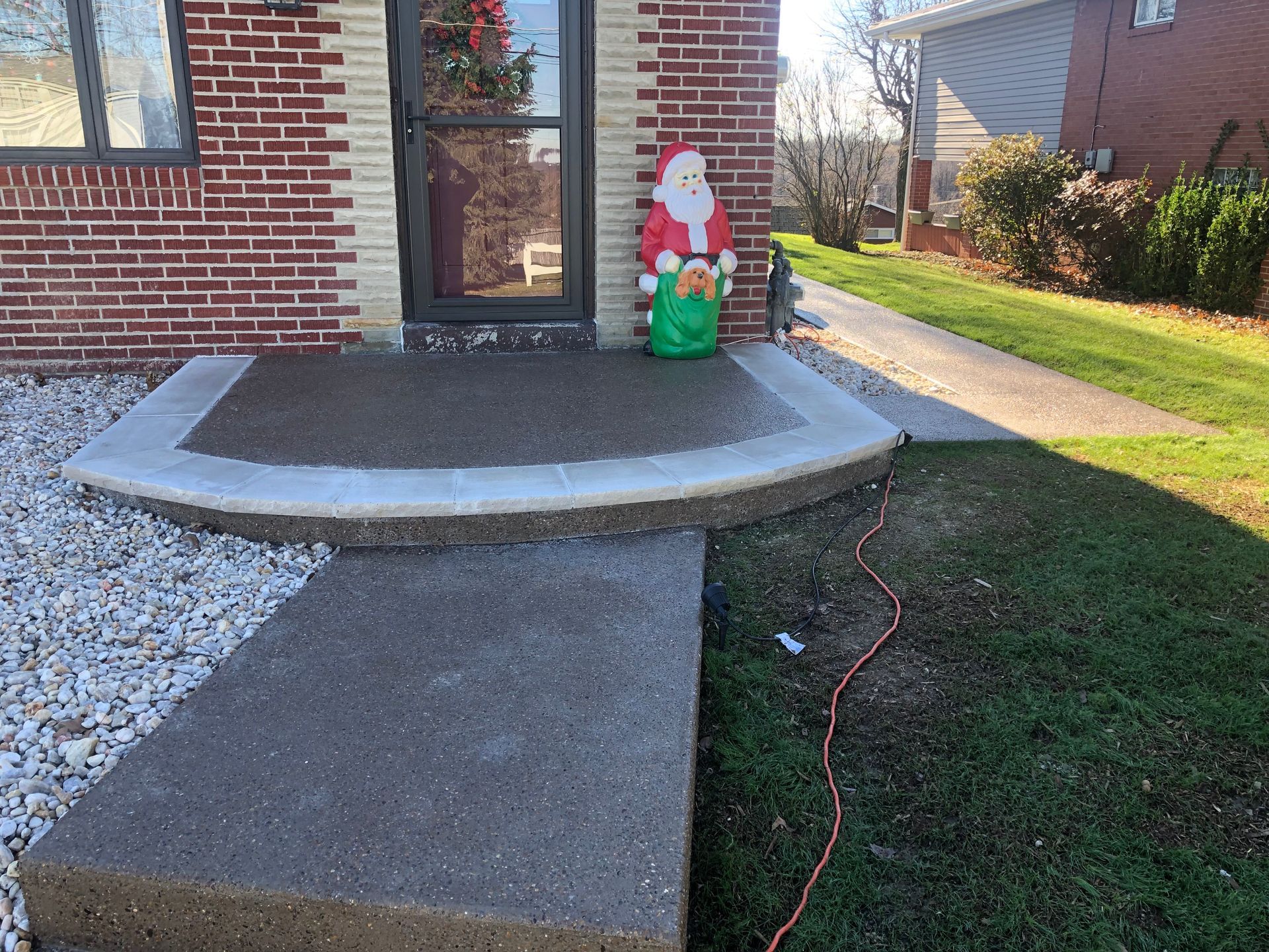 A brick house with a santa claus statue in front of it