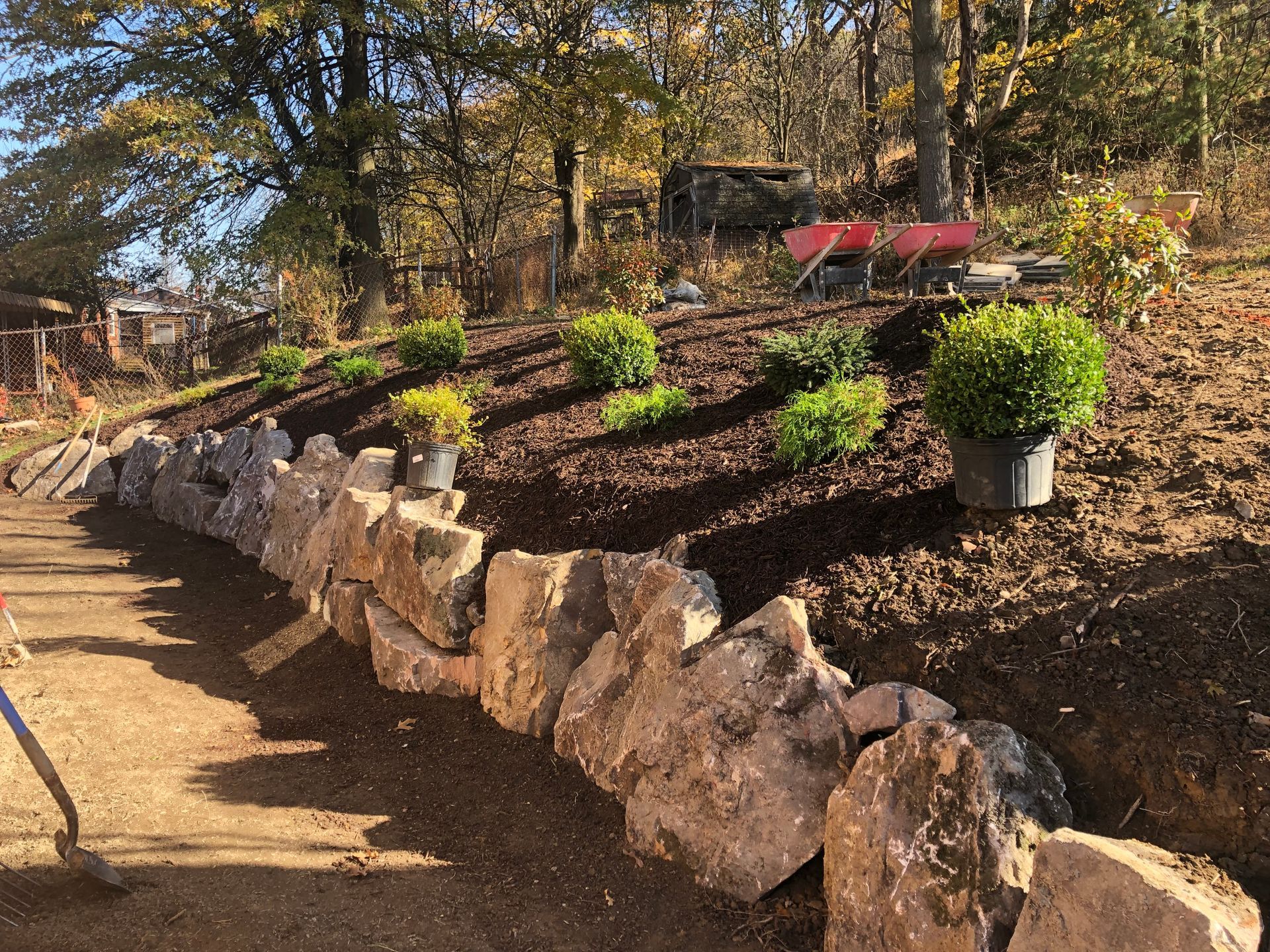 A stone wall is being built on top of a dirt hill.