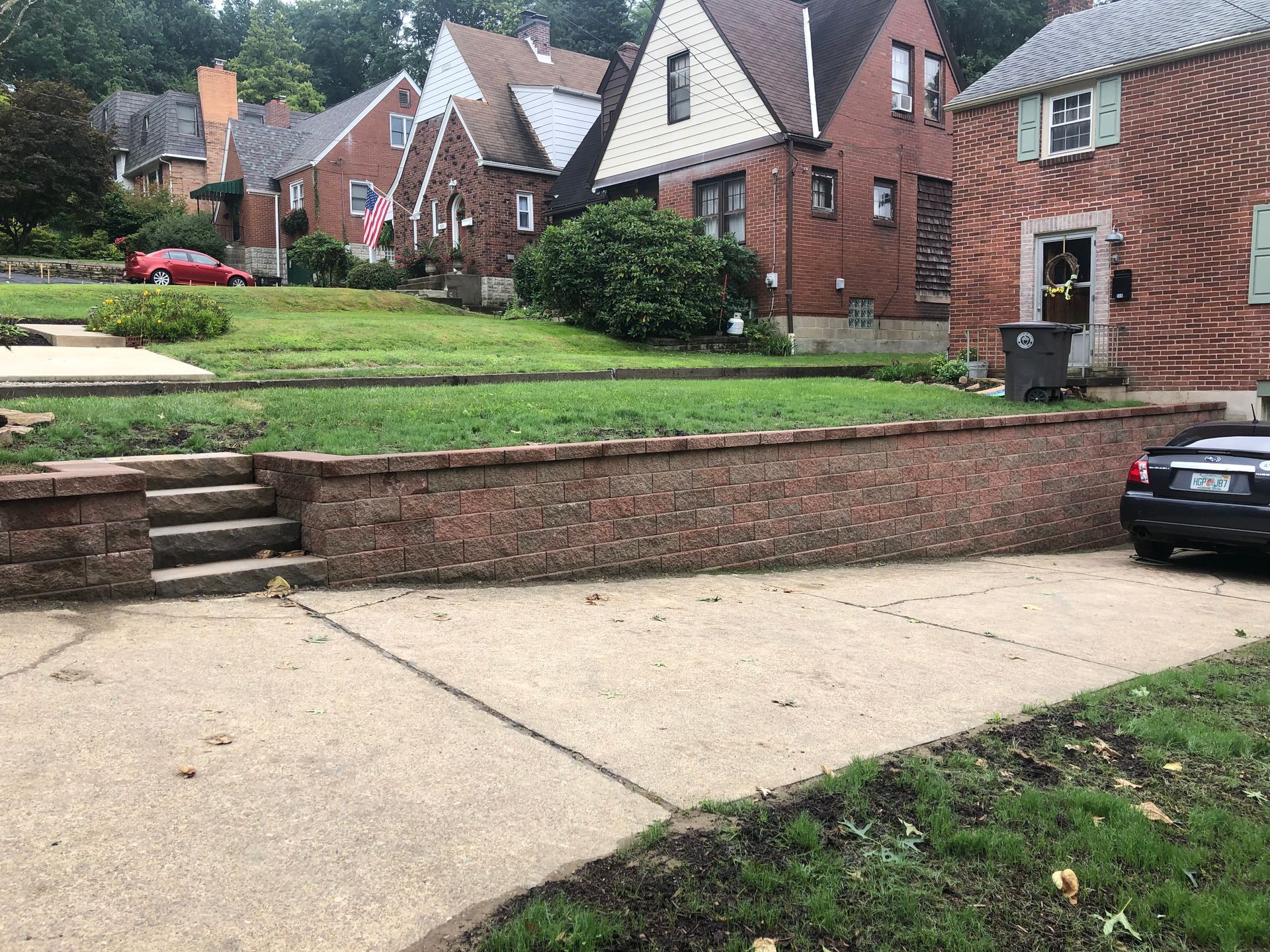 A car is parked on the sidewalk in front of a row of houses.
