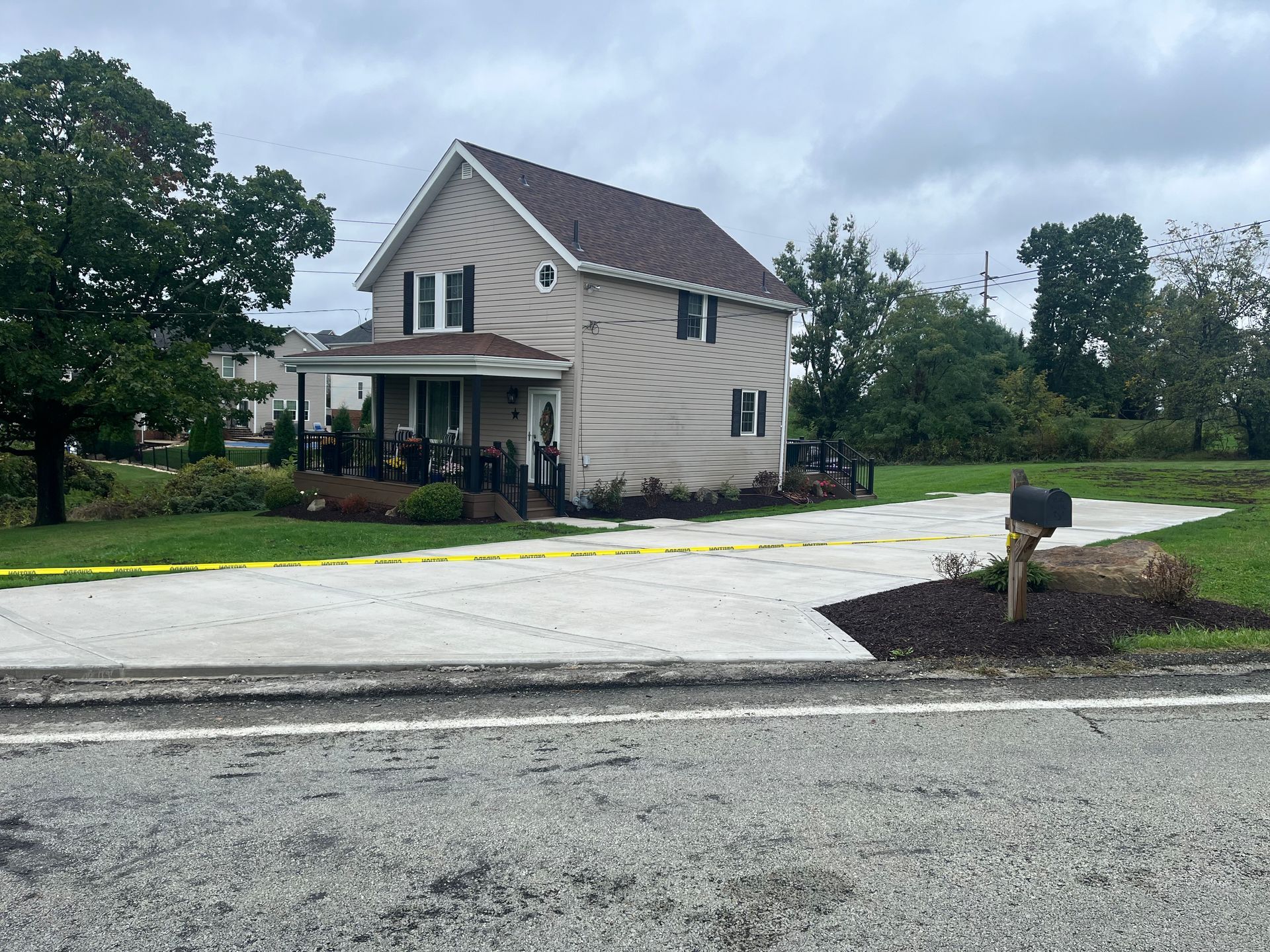 A house is sitting on the side of the road next to a mailbox.
