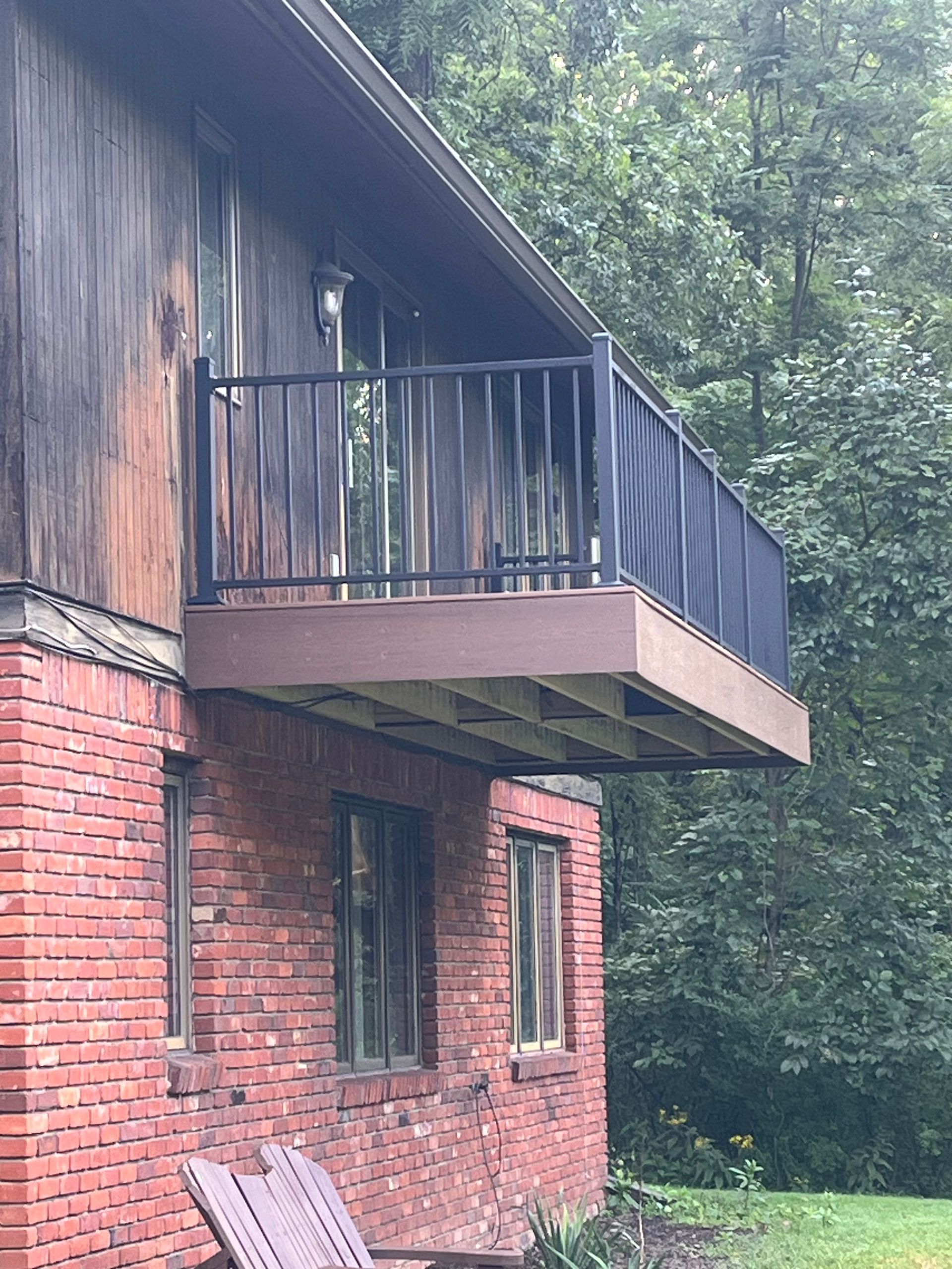 A brick house with a balcony on the side of it