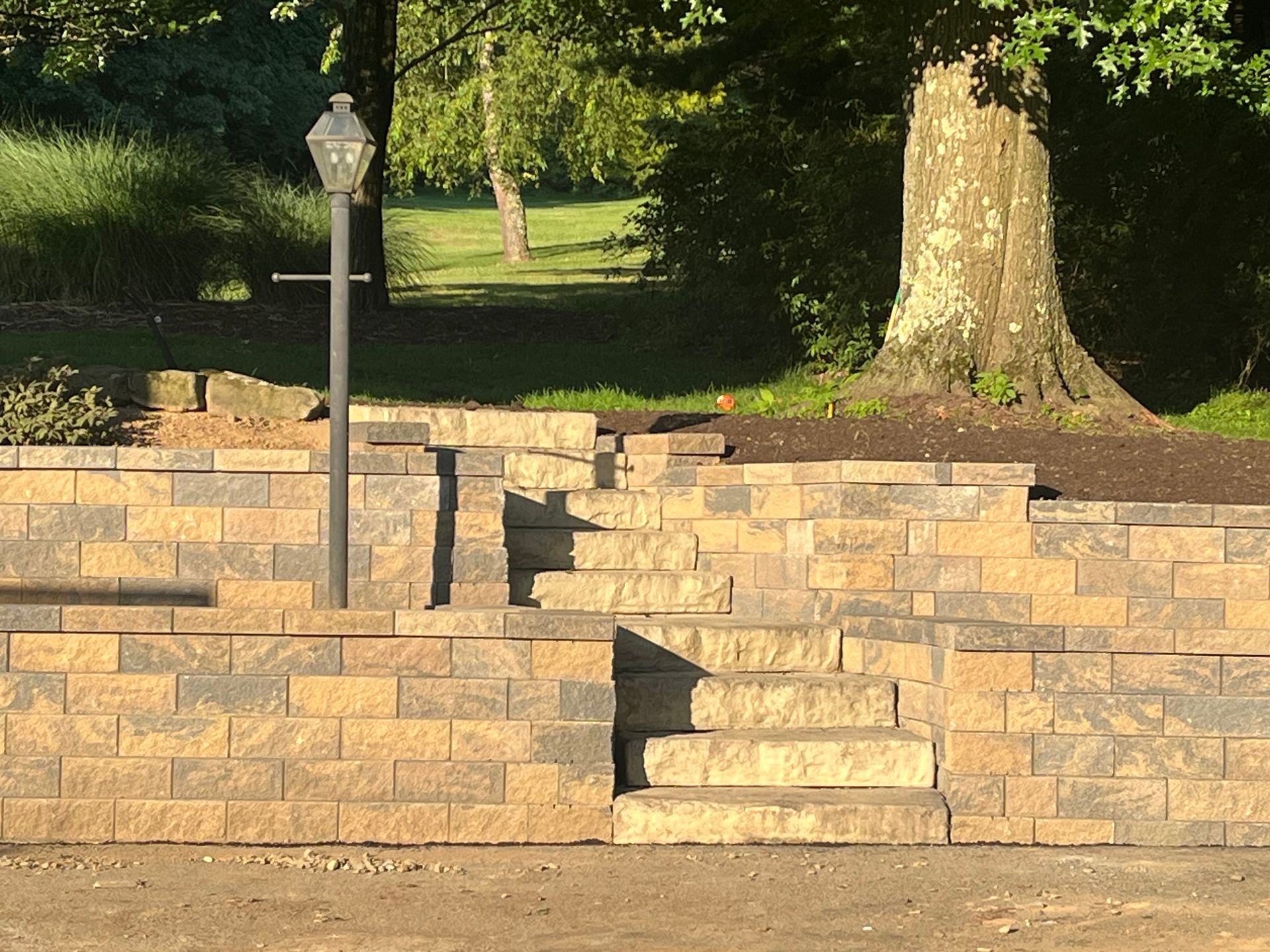 A brick wall with stairs and a lamp post