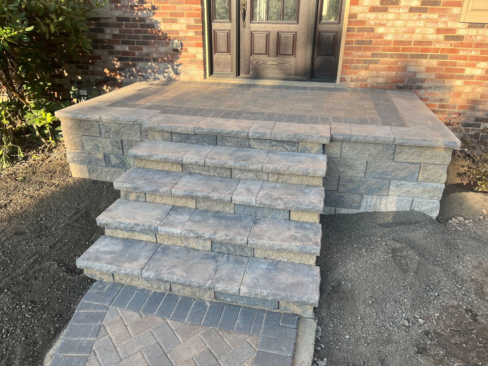 A set of stairs leading up to the front door of a brick house.