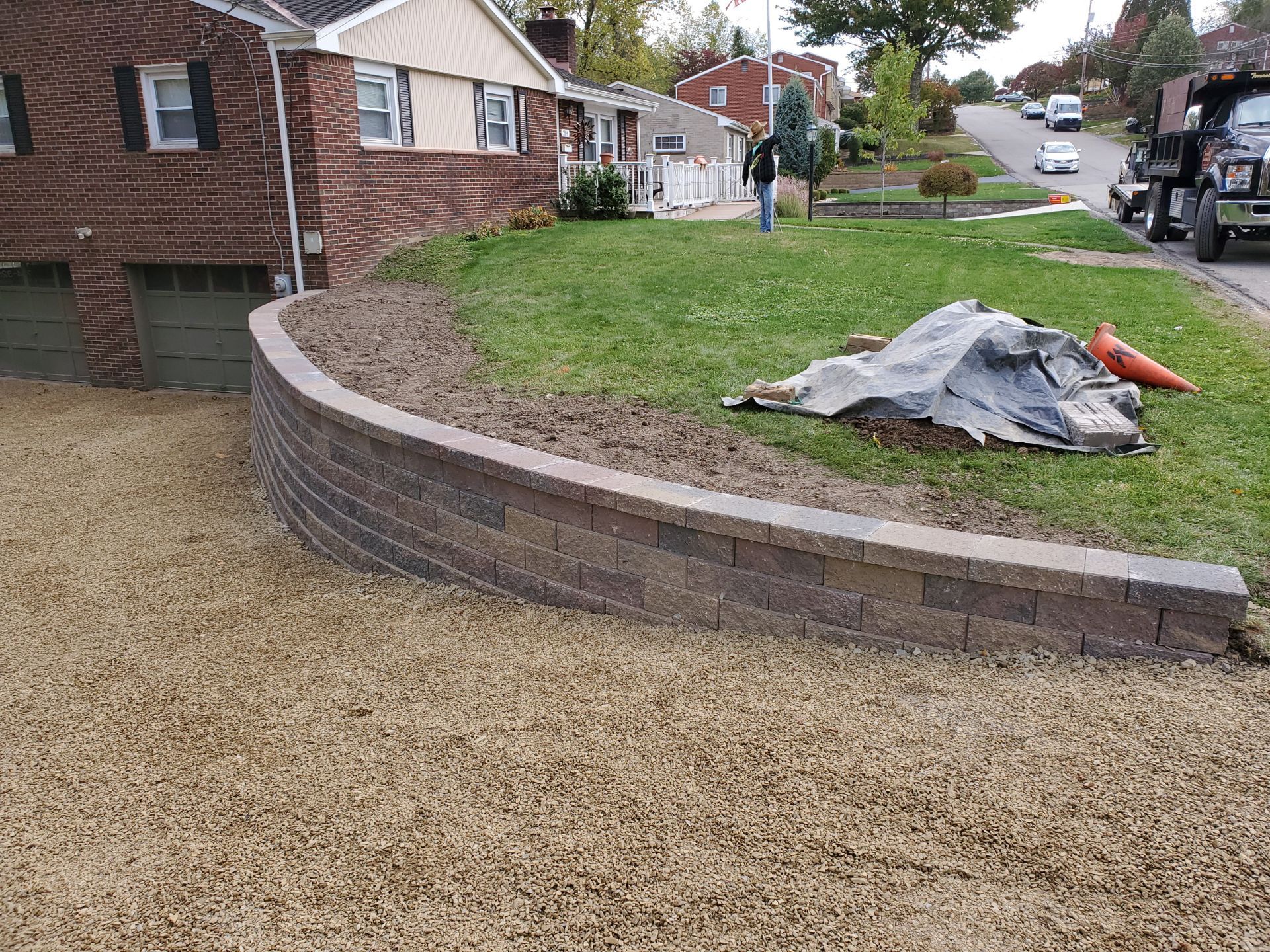 A brick wall is being built in front of a house.