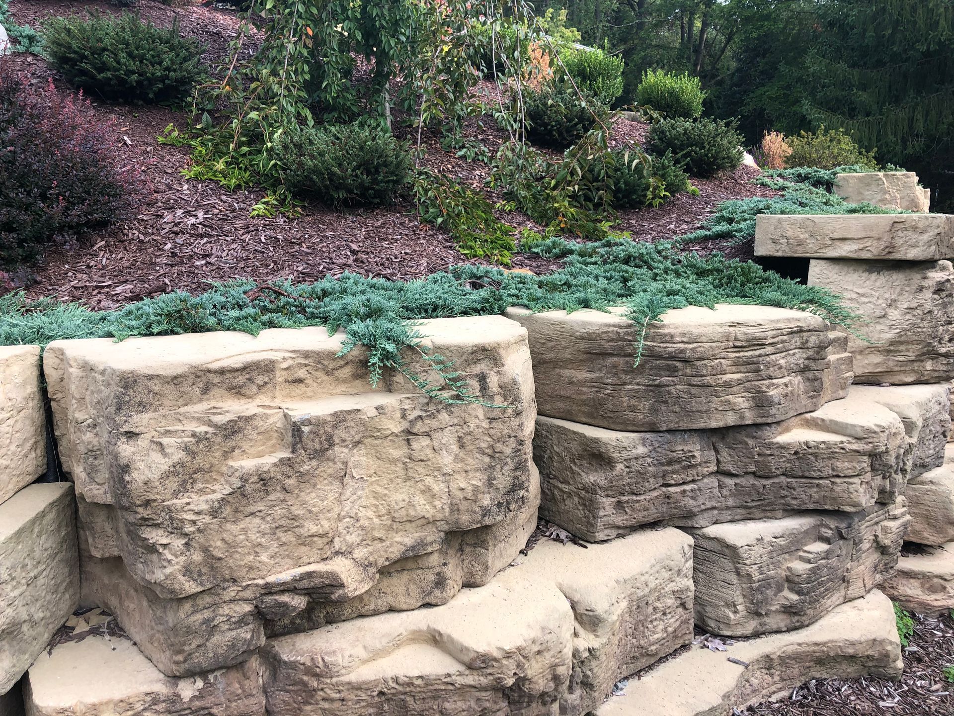 A pile of rocks sitting on top of a hill in a garden.