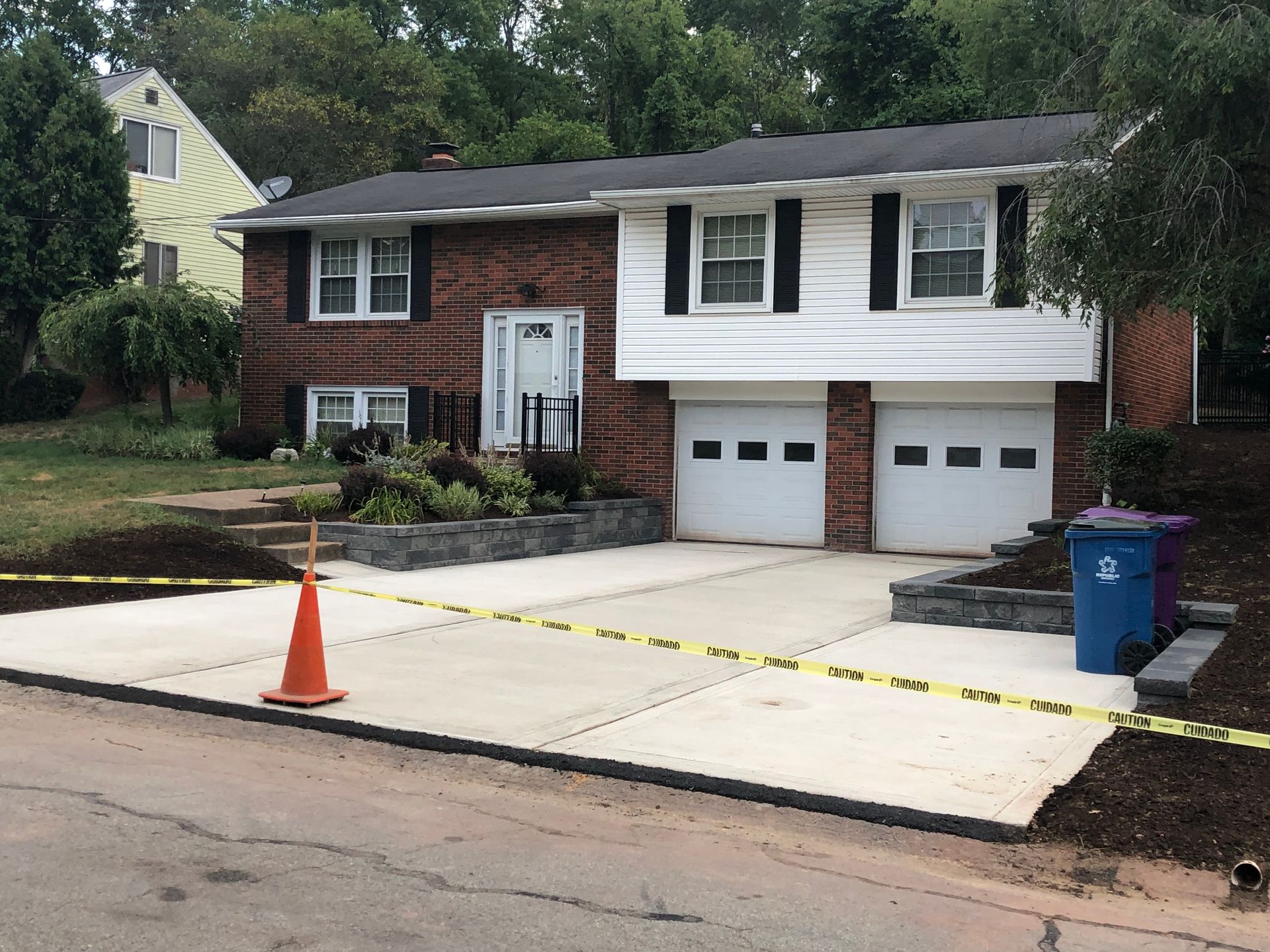 A brick house with a white garage door and a concrete driveway