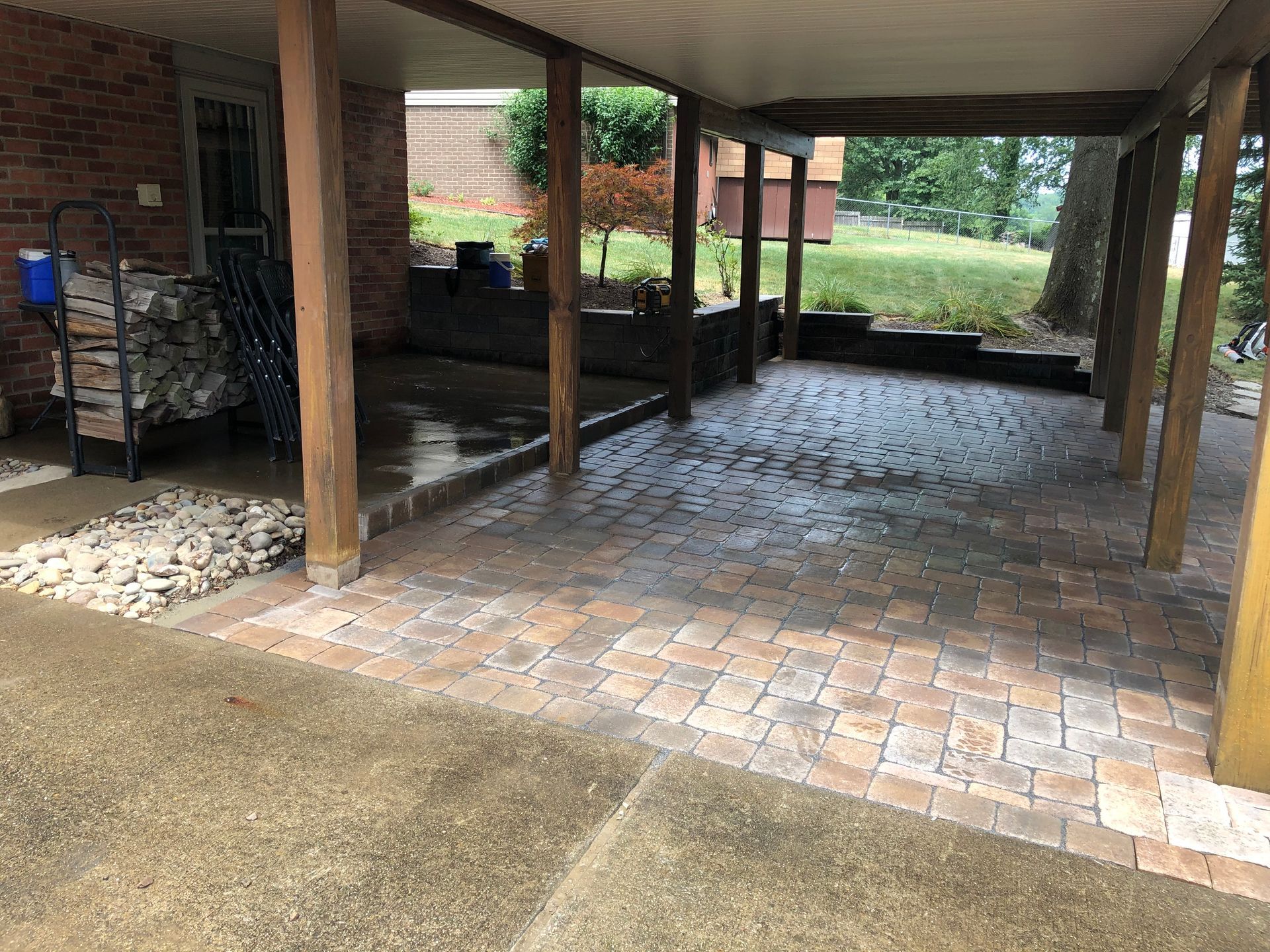 A brick driveway with a covered porch and a brick patio.